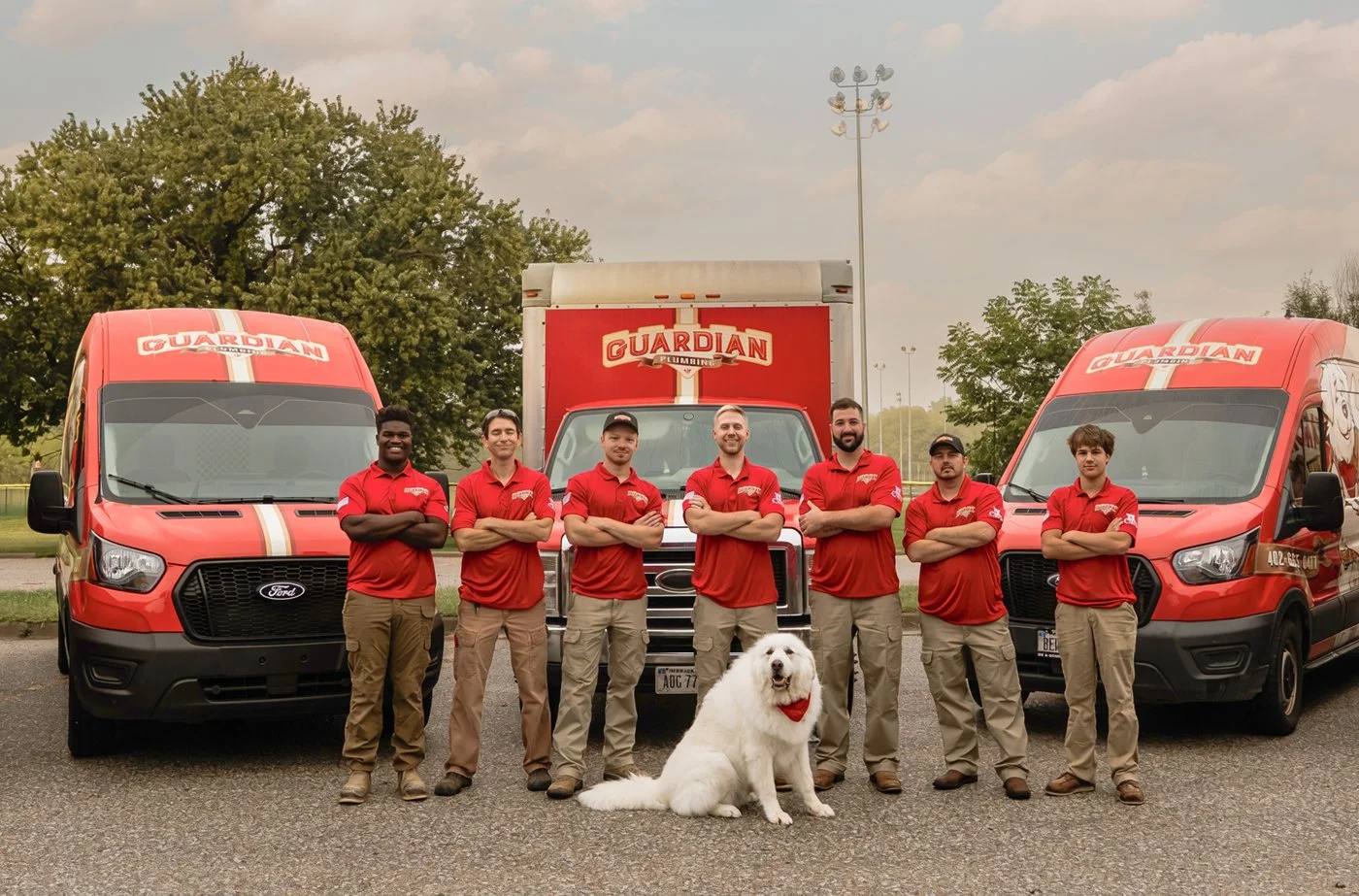 The Guardian Plumbing crew lined up between their service vans